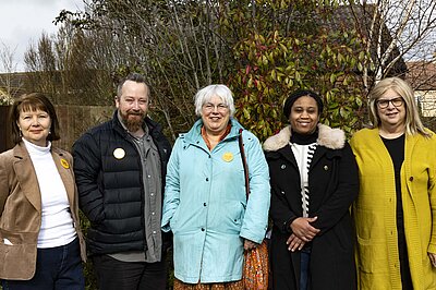 Group of Lib Dems stood in front of greenery